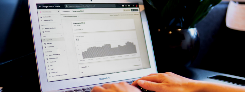 A person using Google Search Console on a MacBook Air, reviewing a 404 error report related to website performance and SEO.