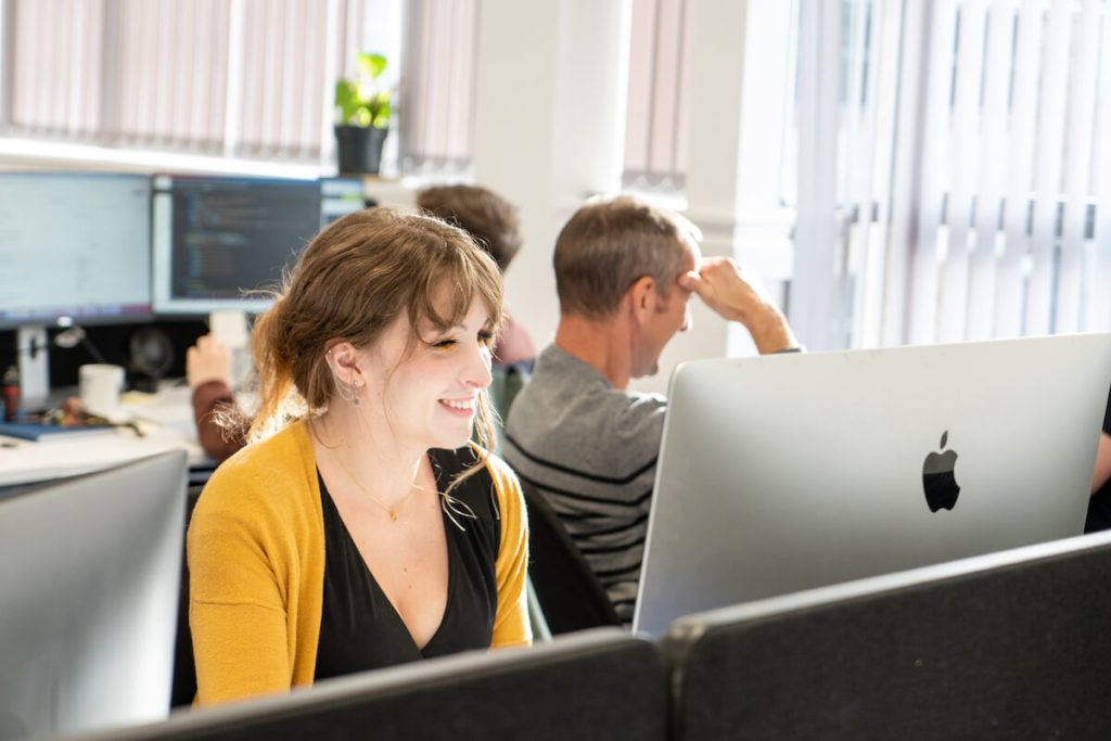 person smiling sat at computer