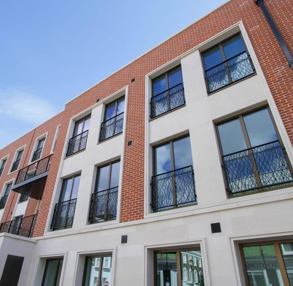 Double glazing marketing on A modern red brick residential building with large aluminium-framed windows