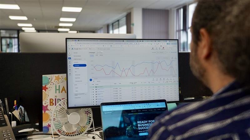 PPC management campaign performance dashboard on screen with analyst reviewing Google Ads results